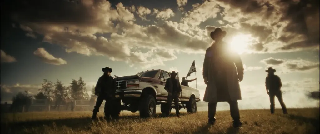 Silhouetted group of cowboys and a lifted pickup in a field against a dramatic sunlit, cloud-filled sky - Amon Amarth