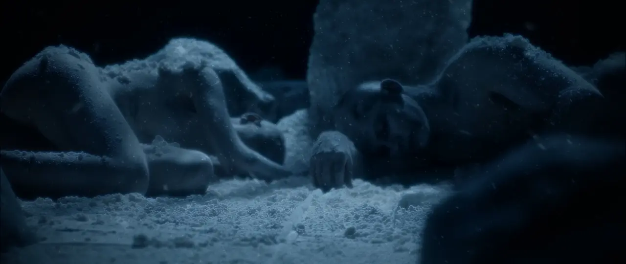 Behemoth Mystic still - a frost-covered figure lying in the snow, eyes open, hand reaching forward