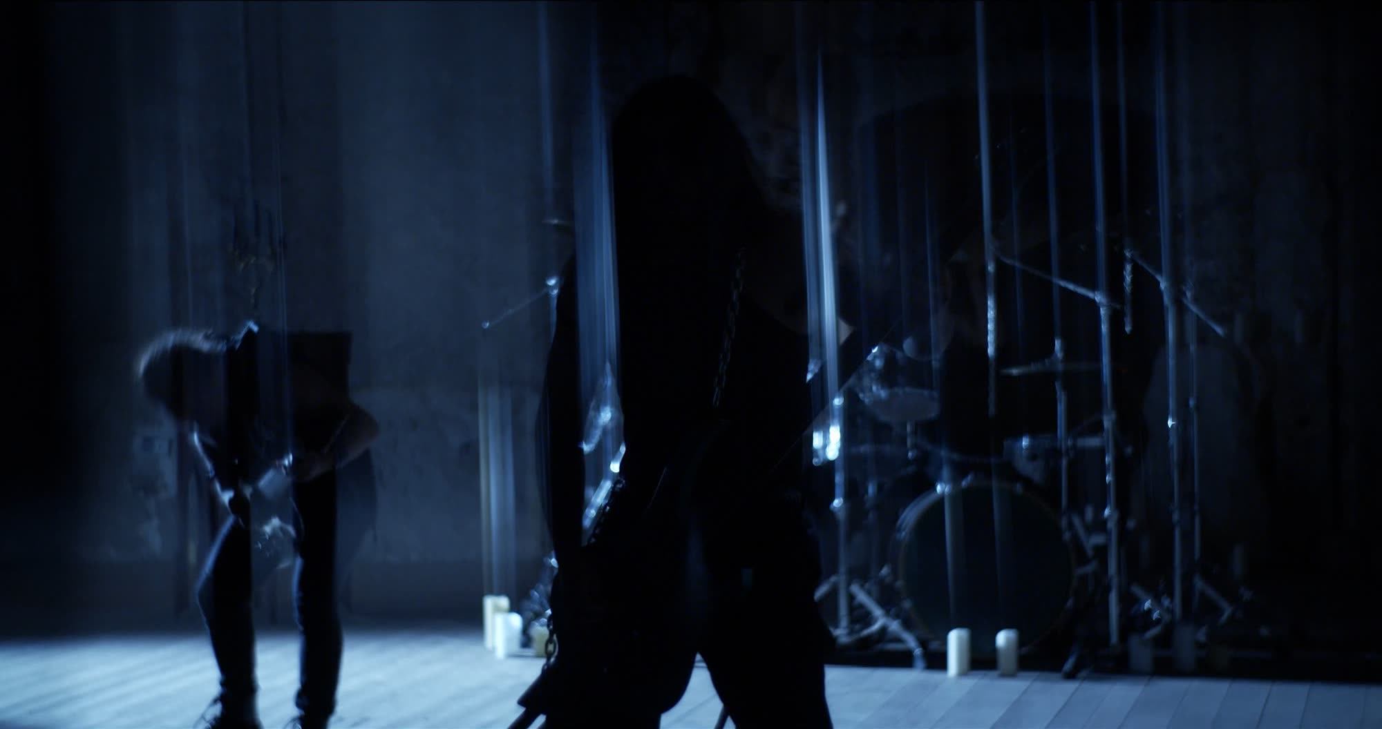 Ater music video still - band performing behind reeded glass, long exposure light trails