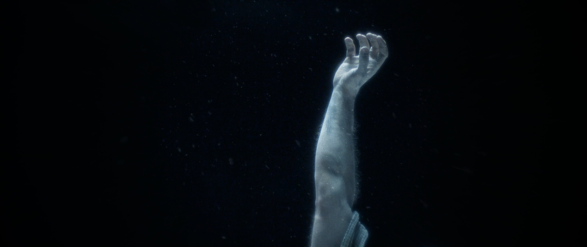 Behemoth Mystic still - a single pale arm reaching up out of darkness
