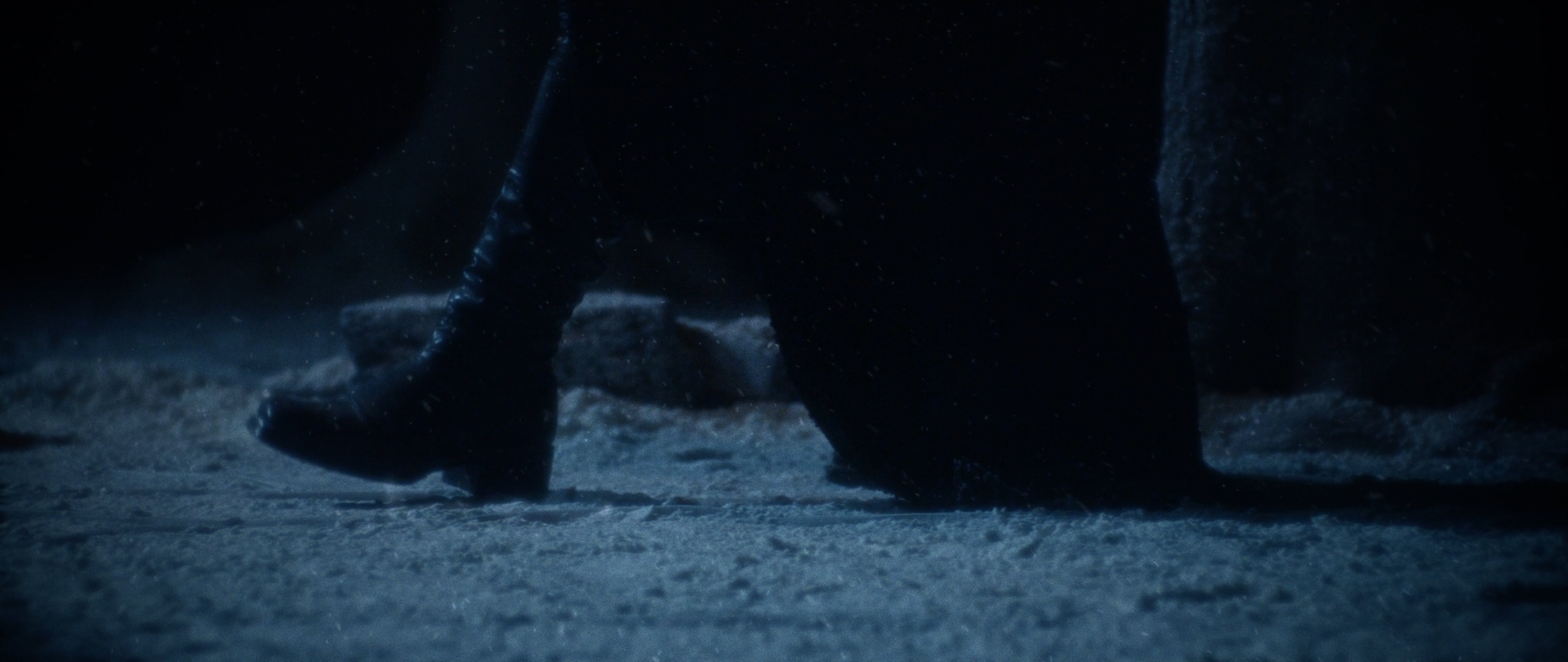 Behemoth Mystic still - low-angle close-up of boots and cloak hems walking through snow