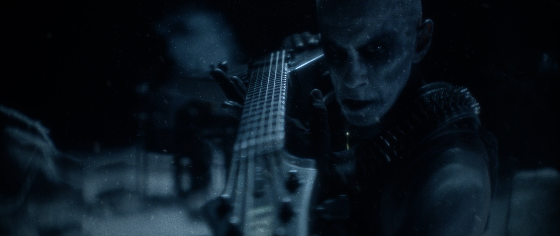 Behemoth Mystic still - corpsepainted musician leaning into a guitar neck, spiked shoulder armor catching the light