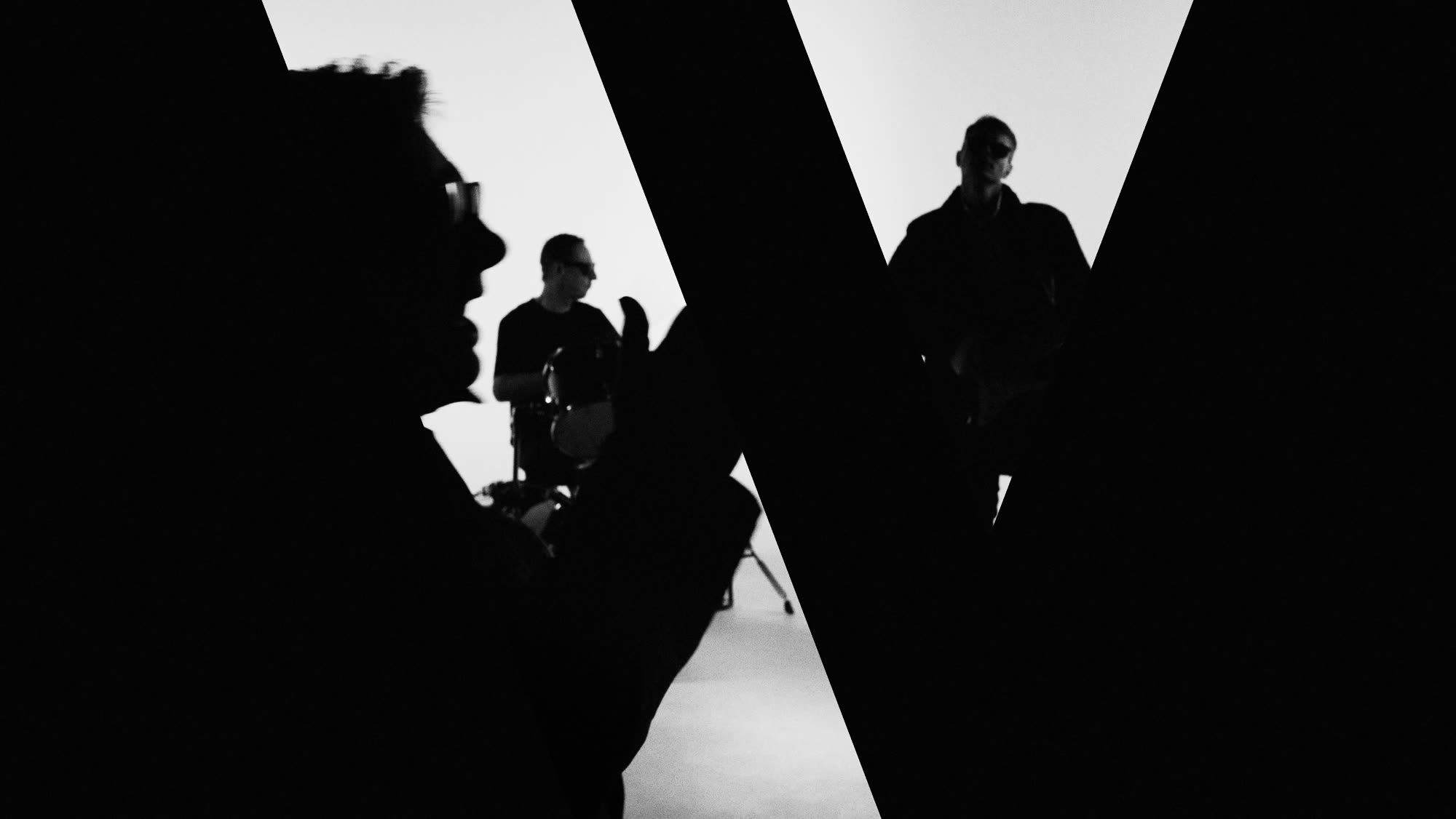 Dzień i noc still - musicians silhouetted behind reeded glass, studio lit white behind them
