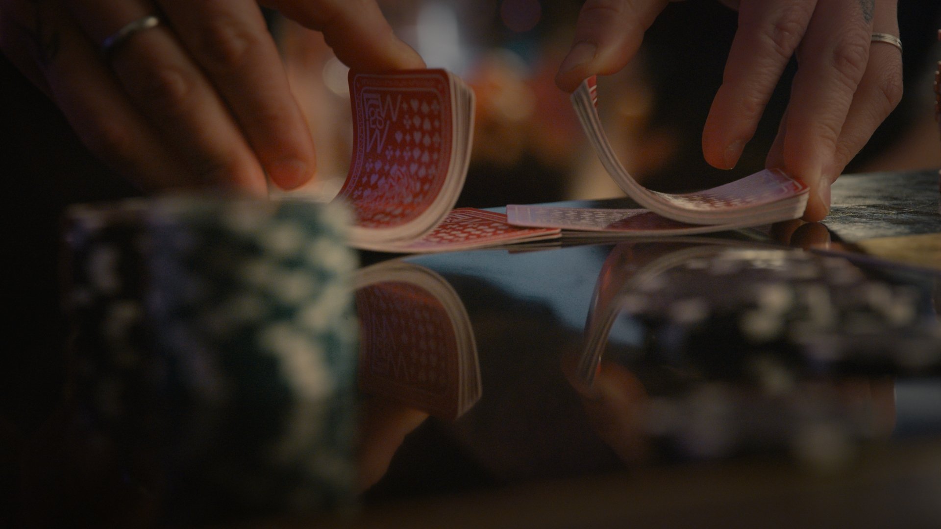 Close-up of hands sorting through photographs on a table - Wrocław Fashion Week 2025