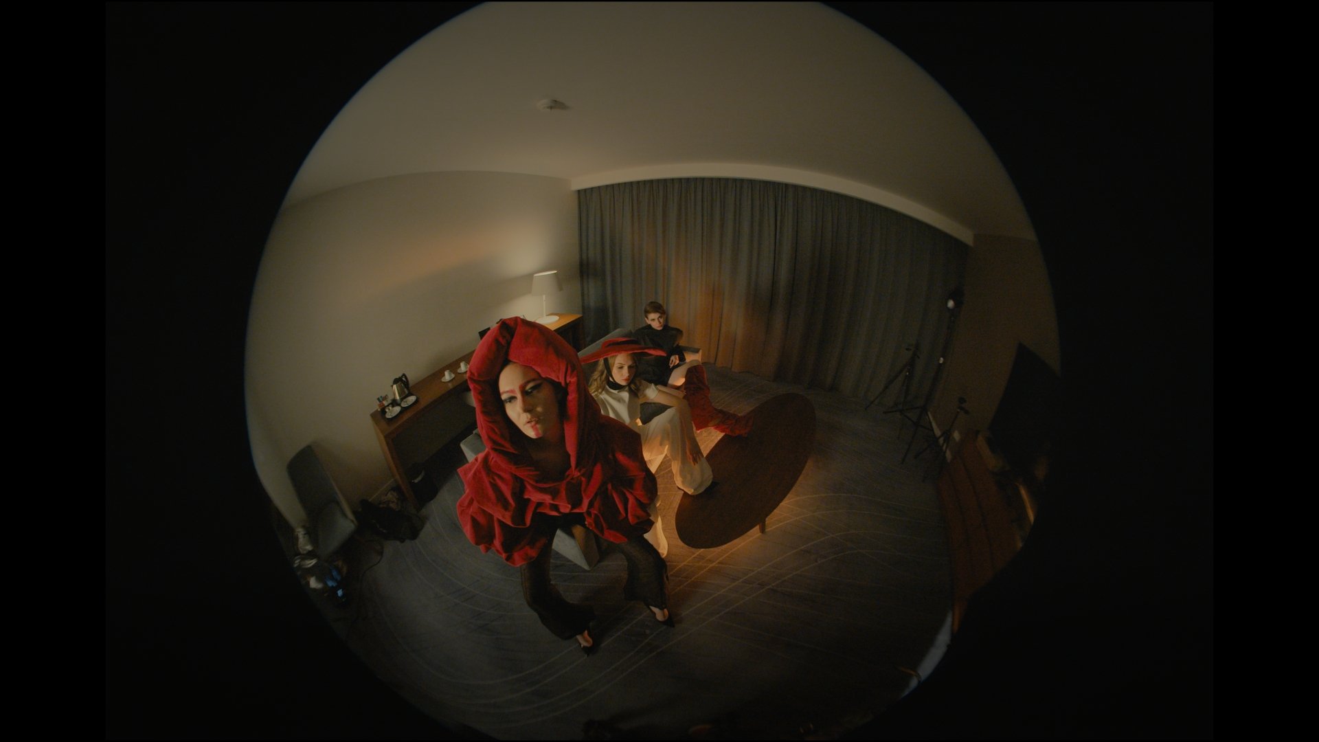 Fisheye shot of a masked figure in a red costume on a bed - Wrocław Fashion Week 2025