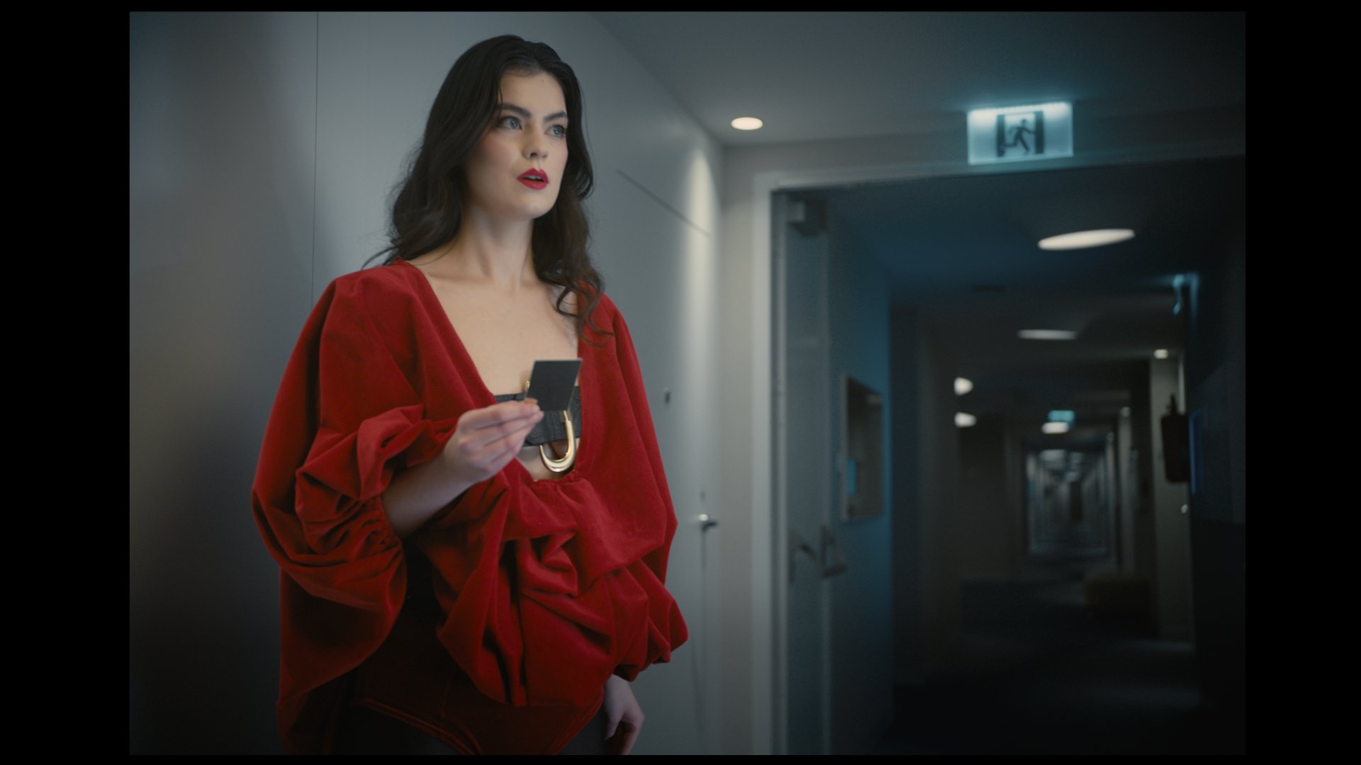 Woman in a red dress on the phone in a hotel corridor - Wrocław Fashion Week 2025