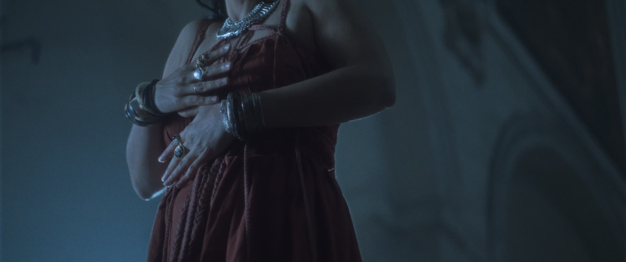 IGORRR music video still - detail of jewelled rings on hands crossed over a dress