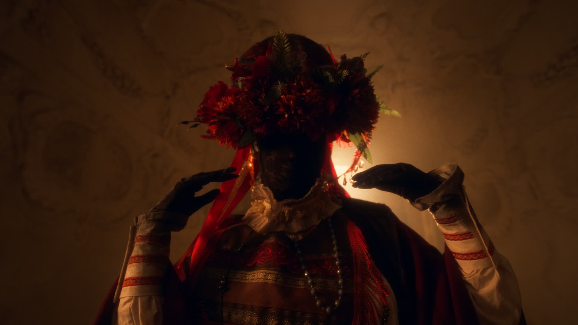 Jestem Alpha still - figure in a floral folk headdress holding a baby, backlit by a tall window