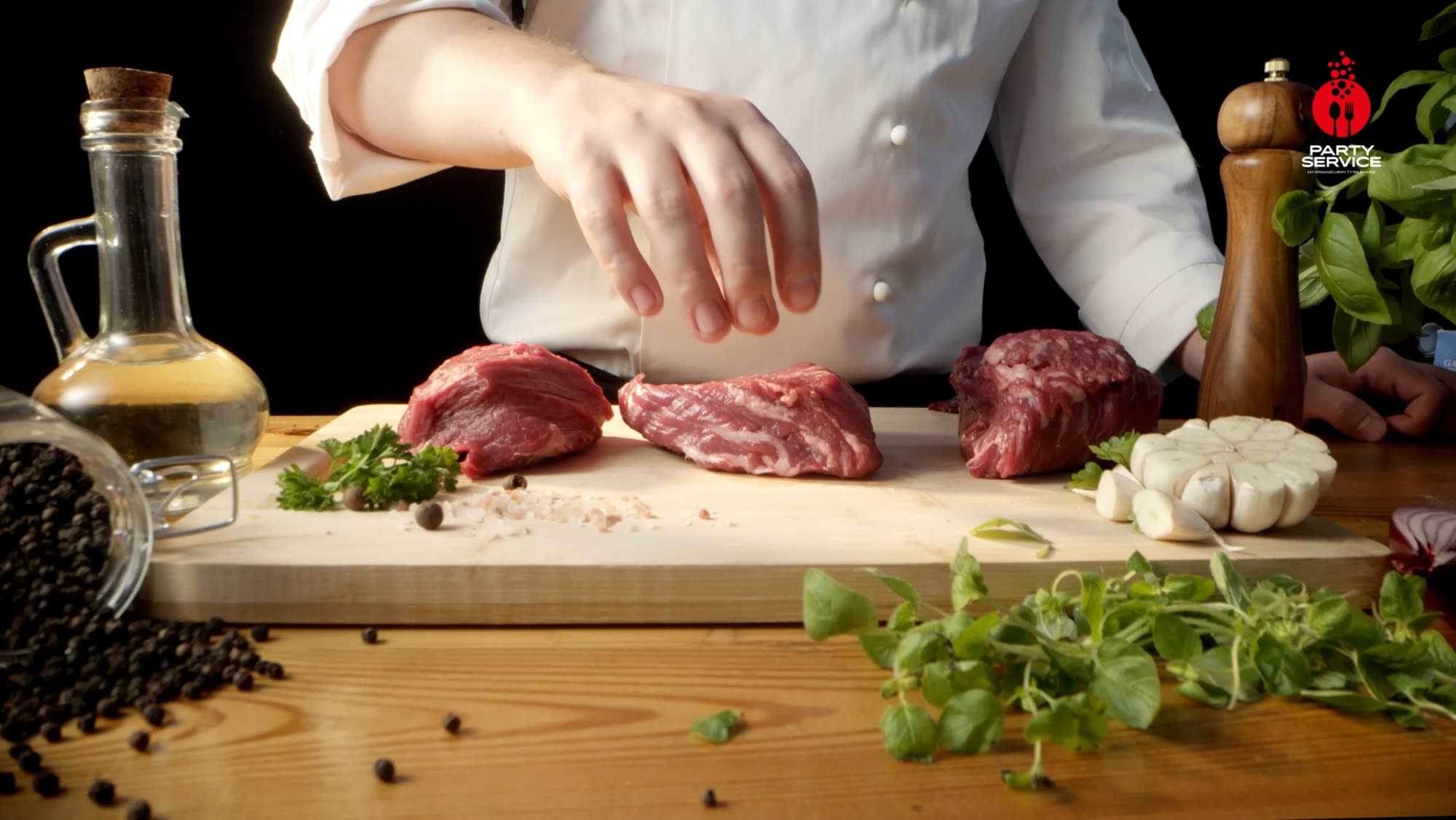 Chef seasoning raw cuts of beef laid out on a board with oil, salt and garlic - Party Service commercial