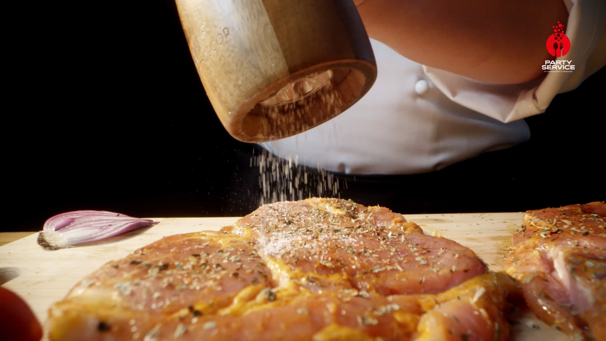 Seasoned steak seared on an open grill, tongs lifting it through smoke and firelight - Party Service commercial