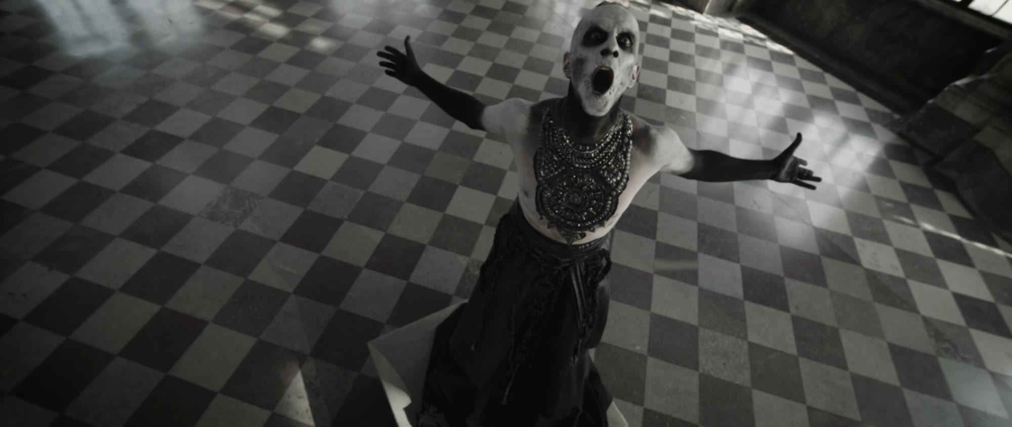 Behemoth music video still - figure with arms spread wide, screaming, on a checkered floor