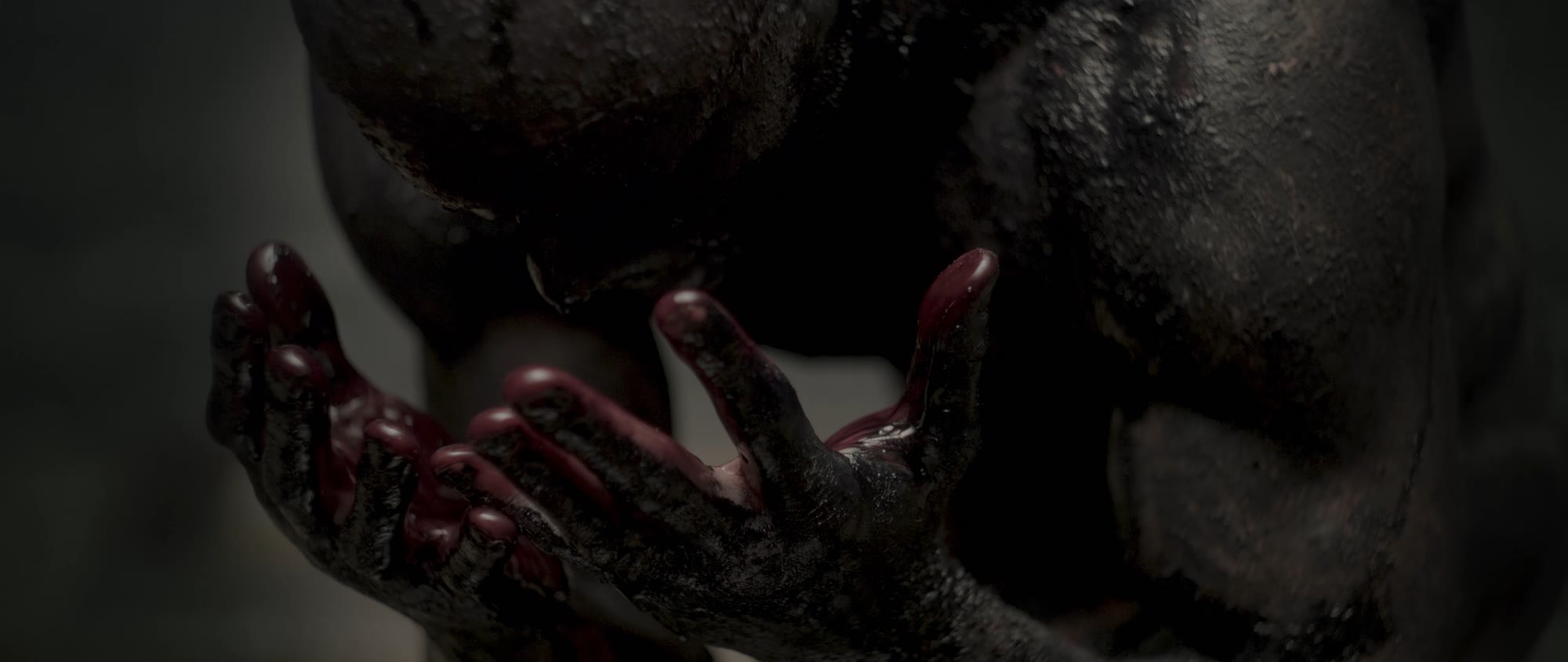 Behemoth music video still - close-up of blood dripping between clasped hands