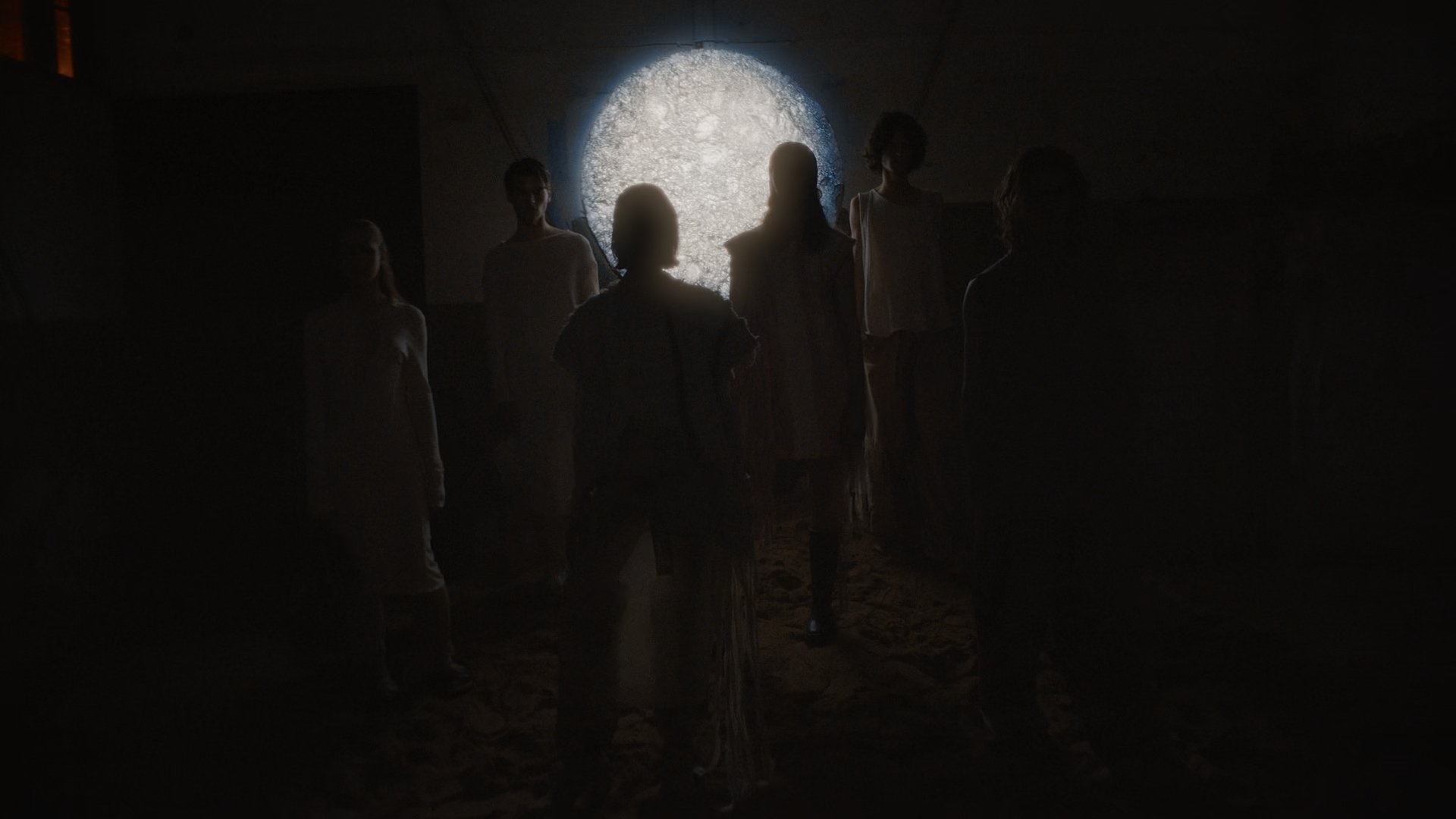 Crowd silhouetted before a glowing circular window - Wrocław Fashion Week Collections