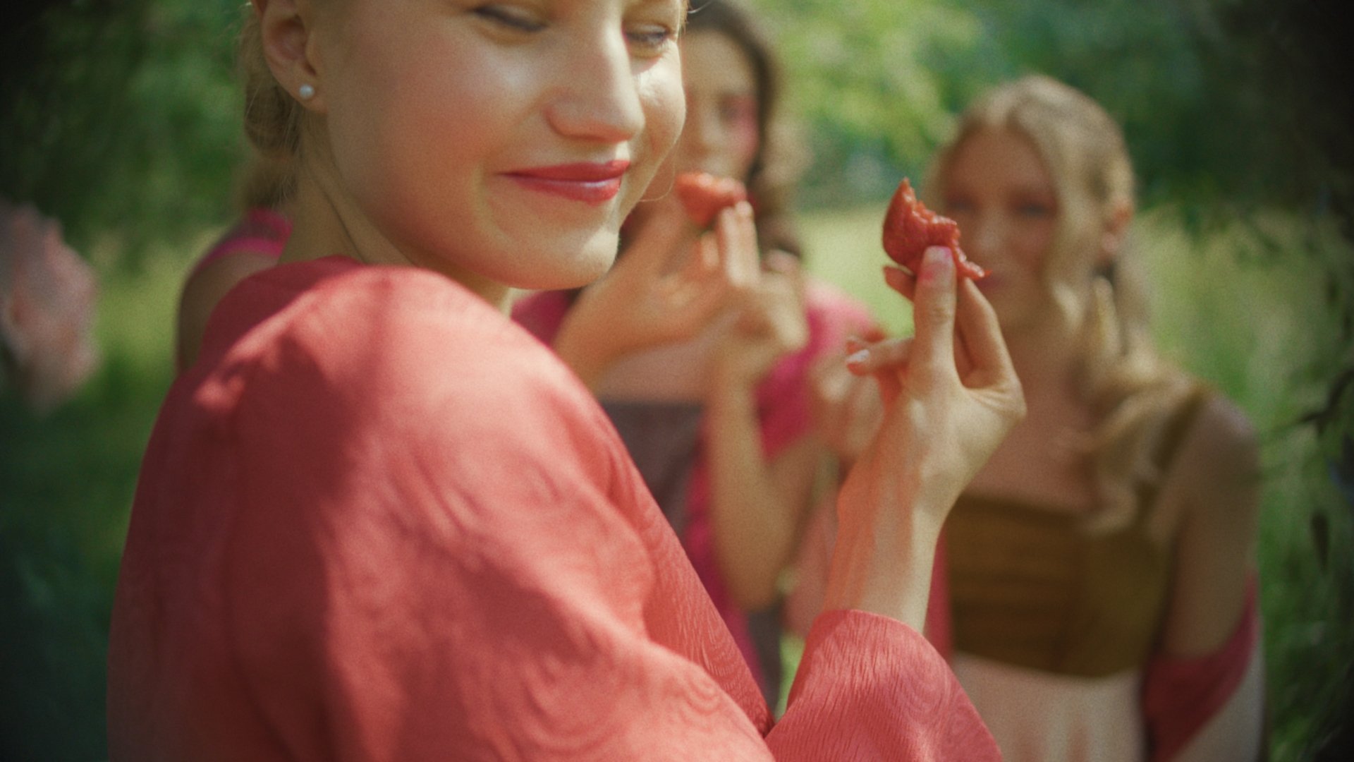 Woman in a coral gown applying red lipstick - Wrocław Fashion Week Collections
