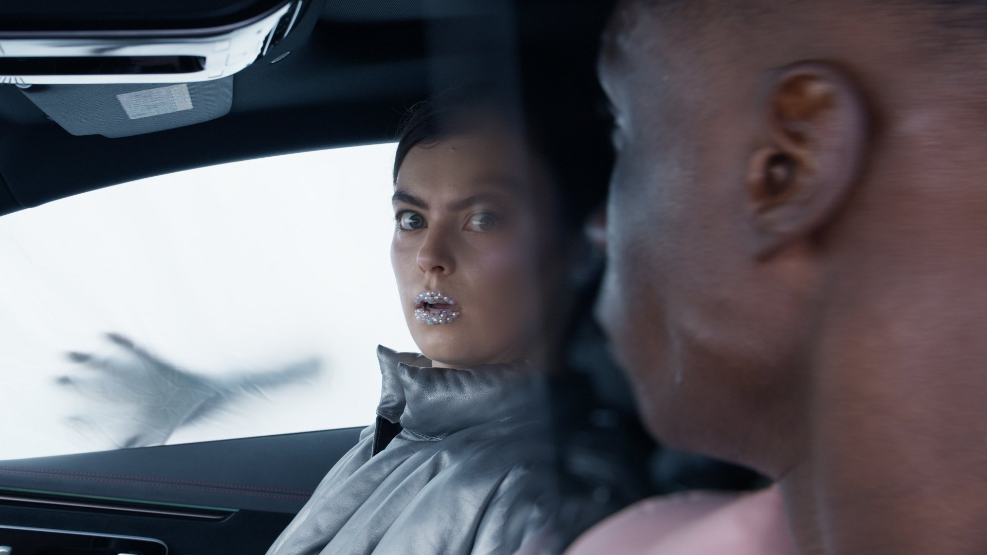 Blurred close-up through a car window, a hand reaching past a man's profile - Wrocław Fashion Week Collections