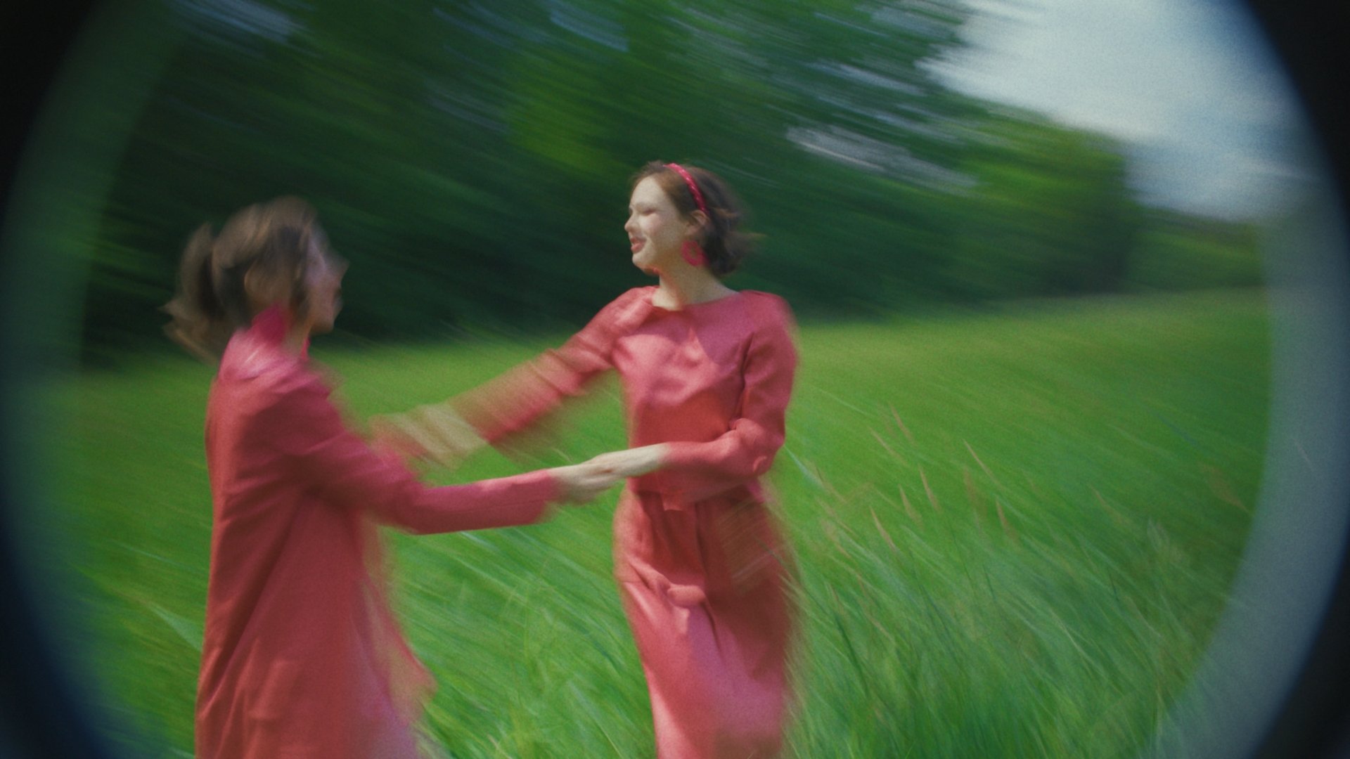 Two models in pink dresses spinning on grass, shot on a fisheye lens - Wrocław Fashion Week Collections