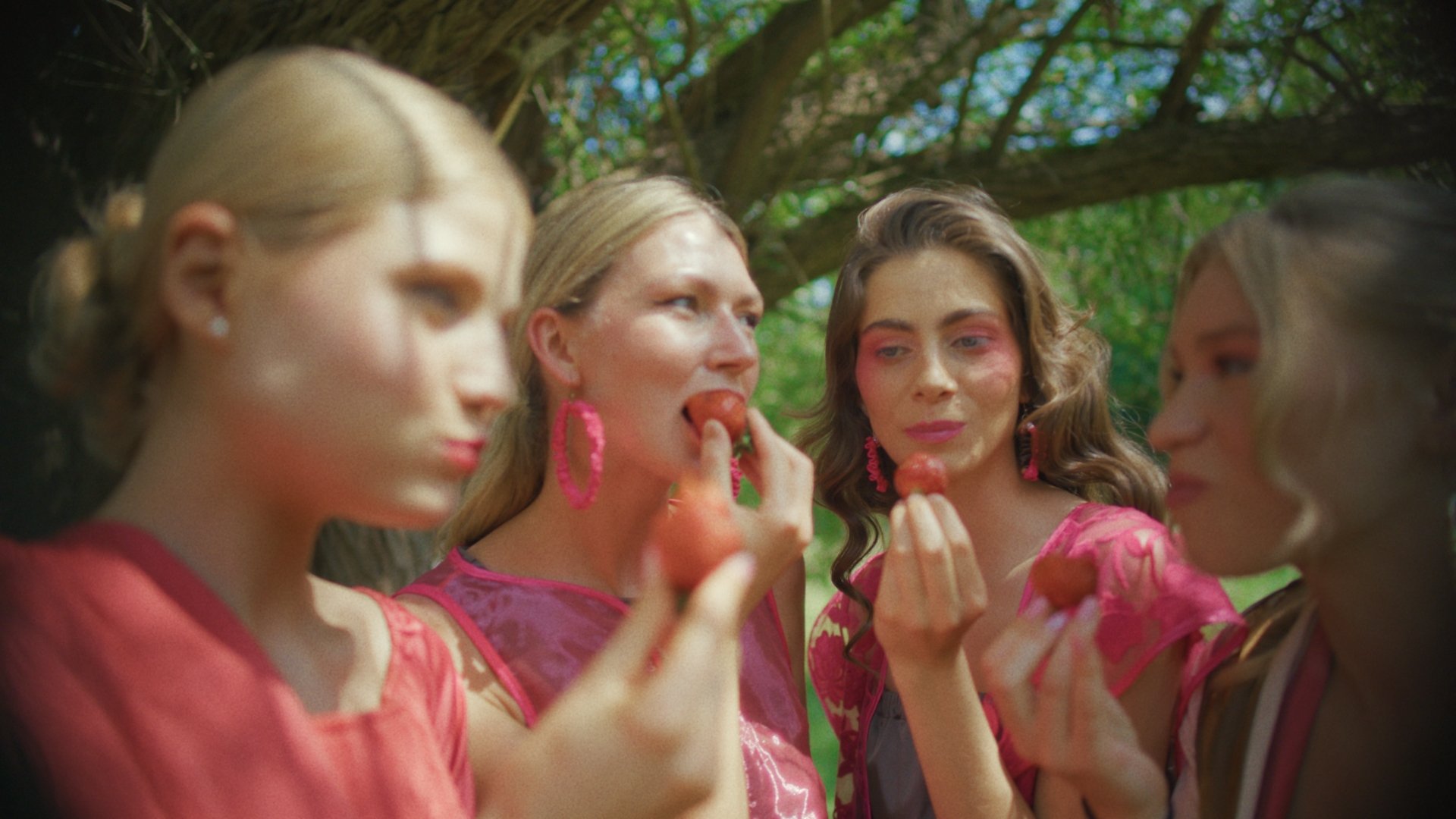 Three models applying lipstick together outdoors - Wrocław Fashion Week Collections