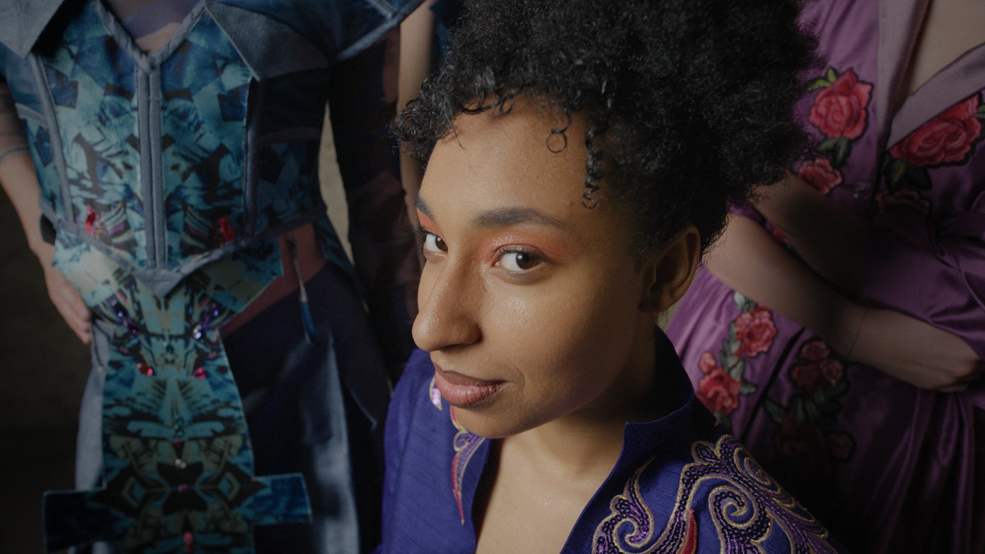 Close-up portrait of a model with curly hair in a colorful patterned top - Wrocław Fashion Week Collections